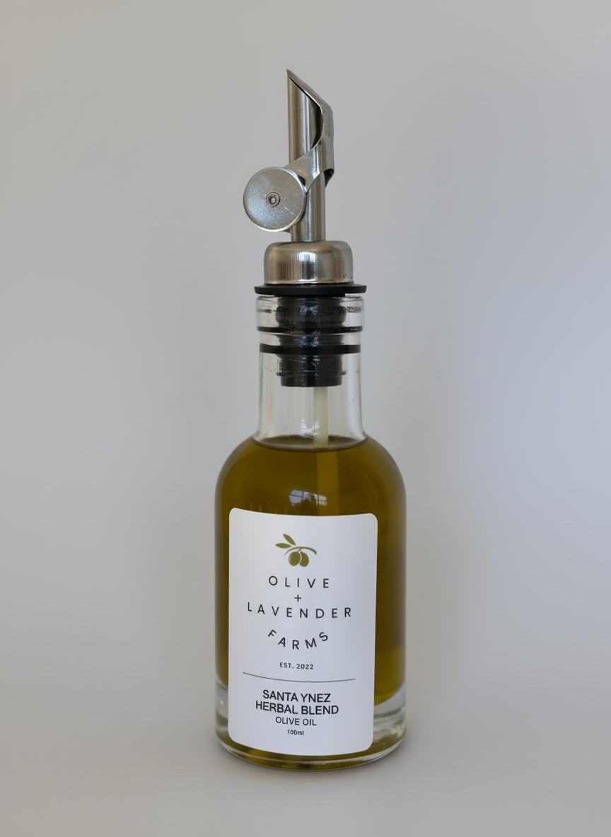 Bottle of Olive Lavender Farms olive oil with a silver pump on a neutral background