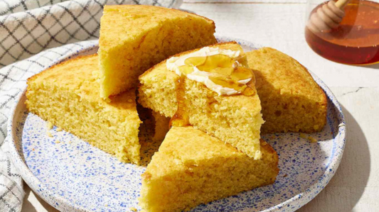 slices of cornbread on dish with honey and butter