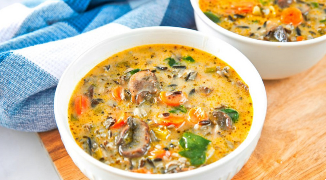 Soup with vegetables and broth in a white bowl