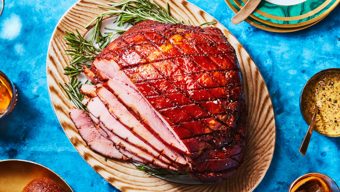 Balsamic glazed ham on a serving platter drizzled with Olive + Lavender Farms Barrel Aged Balsamic Vinegar
