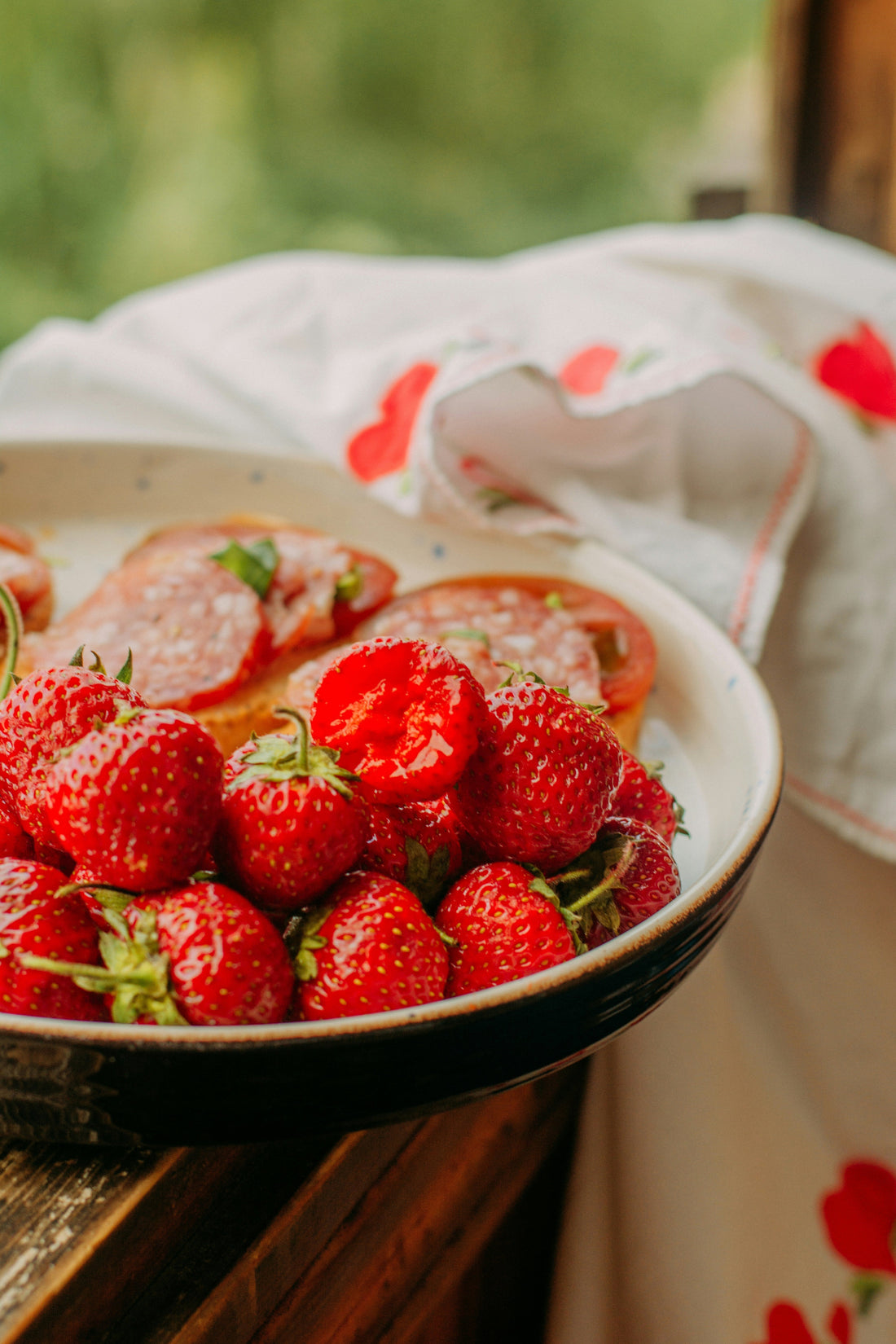Ripe strawberries piled on a plate positioned the kitchen window