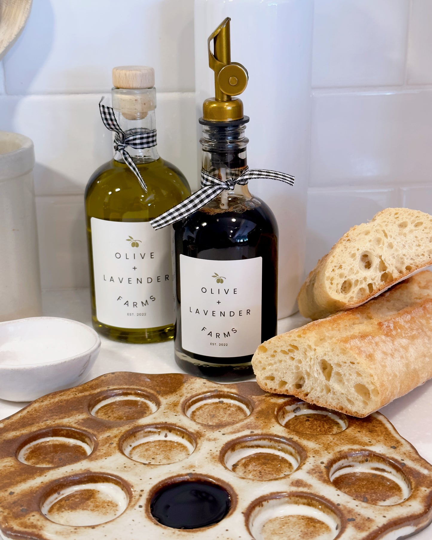 Dark balsamic vinegar from Olive & Lavender Farms on a kitchen counter with dipping plate.