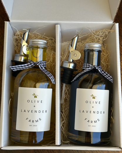 Two bottles of Olive + Lavender Farms products in a box with decorative ribbons and pour spouts.